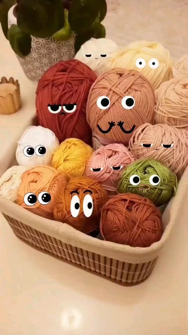 A basket of yarn balls with googly-eye faces drawn on